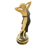 Reproduction Art Deco figure in metal and plastic on circular base, 23cm high