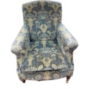 Early 20th Century floral upholstered armchair raised on turned legs with castors