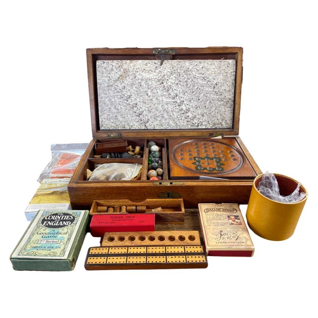 Mahogany box with an interior with games compendium featuring marbles, chess pieces, playing cards
