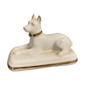 Mid 19th Century model of a recumbent dog on rectangular base with gilt highlights, possibly Granger