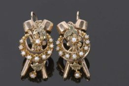 Pair of yellow metal and seed pearl earrings centering a flower within a crescent, highlighted