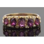 Victorian garnet and diamond ring featuring five graduated oval cut garnets, highlighted between