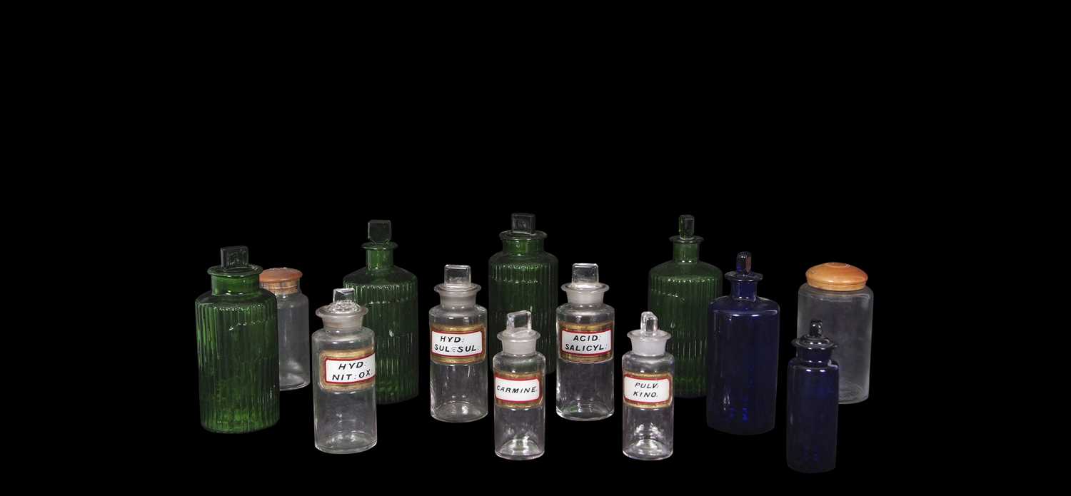 Quantity of clear glass and coloured glass chemist jars with covers or stoppers including four