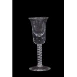 A wine glass with bowl shaped bowl above a clear stem with opaque tape and multi-ply spiral band,