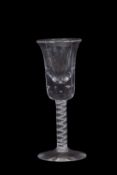 A wine glass with bowl shaped bowl above a clear stem with opaque tape and multi-ply spiral band,