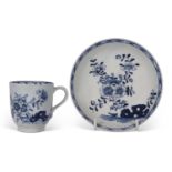 Lowestoft coffee cup and saucer painted in blue and white with a floral and rock pattern
