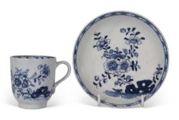 Lowestoft coffee cup and saucer painted in blue and white with a floral and rock pattern