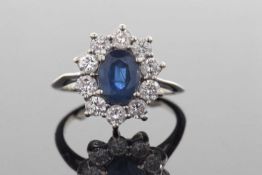 Sapphire and diamond cluster ring, the oval sapphire set within a round brilliant cut diamond