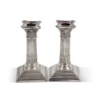 A pair of late Victorian silver encased dressing table candle sticks in neo-classical style having