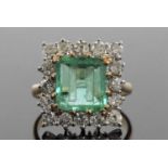 An emerald and diamond ring, the emerald engraved with the letter 'H', 10.19 x 9.62 x 3.15mm,