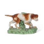 Early 19th Century Derby model of a retriever on a green coloured base, 18cm long (restoration to