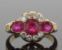 Ruby and diamond triple cluster ring featuring a cushion cut ruby, two oval rubies and eight round