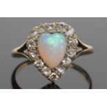 Opal and diamond ring, the heart shaped opal set within a surround of old cut diamonds and raised