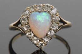 Opal and diamond ring, the heart shaped opal set within a surround of old cut diamonds and raised