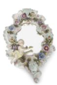 Shaped Sitzendorf mirror surrounded with applied floral decoration and winged cherub