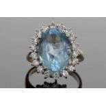 18ct gold blue topaz and diamond cluster ring, the oval faceted blue topaz is 6.96ct approx, set