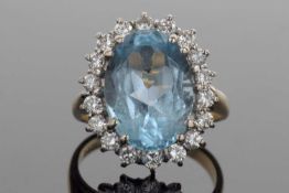 18ct gold blue topaz and diamond cluster ring, the oval faceted blue topaz is 6.96ct approx, set