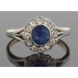 18ct gold sapphire and diamond cluster ring, the oval cut faceted sapphire bezel set within a