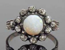 Opal and diamond cluster ring, the round cut cabochon opal multi claw set within an old cut