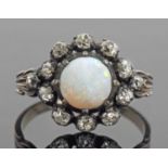 Opal and diamond cluster ring, the round cut cabochon opal multi claw set within an old cut