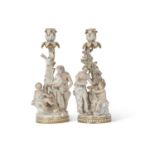 A fine pair of Meissen porcelain candlesticks, 19th Century, one decorated with elderly man and