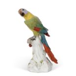A very large meissen model of a parrot seated on a tree stump, brightly coloured, 19th Century,