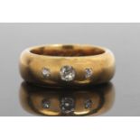Antique three stone diamond ring featuring three graduated old cut diamonds in a plain polished wide