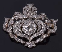 Diamond brooch/pendant, a floral an scrolled design decorated with graduated old cut diamonds