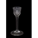 A wine glass, the ogee bowl with engraved floral decoration above a clear stem, 15cm high