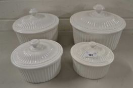 Set of four oval white glazed serving dishes