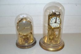 Two brass anniversary clocks under glass domes
