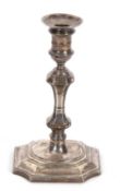 George V taper stick in George II style having shaped square loaded base, knopped stem, integral