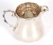 Victorian milk jug of circular baluster form with hollow looped handle, hallmarks badly rubbed,