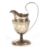George V large pedestal milk jug in neo classical style of fluted oval form to a plain oval foot,
