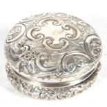 Late Victorian silver box of circular form, embossed and chased with scrolls etc, pull off lid,