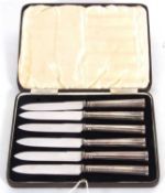 Cased set of six George VI stainless bladed cake knives with fluted oval section silver handles,