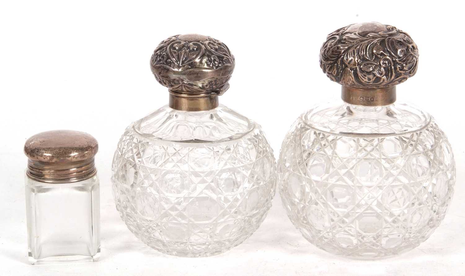 Large cut glass scent bottle of globular form with screw on silver embossed lid, hallmarked for