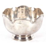 George V silver punch bowl (monteith) of plain squat circular form on a pedestal spreading