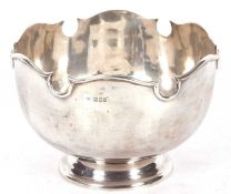 George V silver punch bowl (monteith) of plain squat circular form on a pedestal spreading