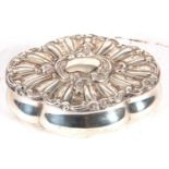 Silver trinket box of shaped oval form, the hinged lid with a fluted design around a vacant