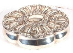 Silver trinket box of shaped oval form, the hinged lid with a fluted design around a vacant