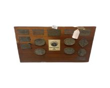 Wooden display boards displaying brass plaques for local vintage car rally's
