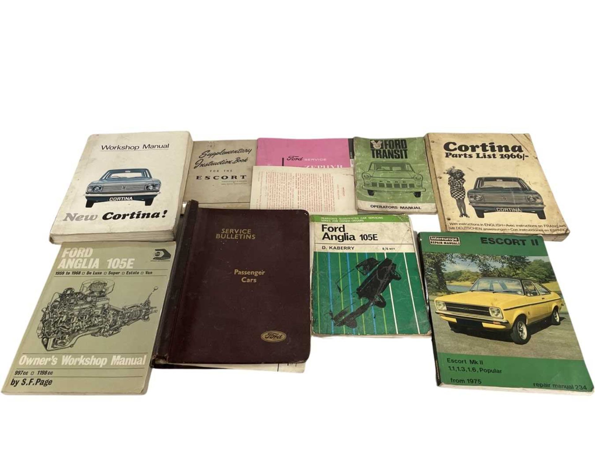 Box containing 11 Ford manuals including Escort, Cortina, Anglia etc