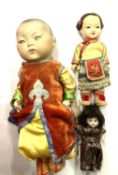 An Armand Marseille bisque Oriental boy doll, in colourful traditional clothing, marked 353/3 1/2K