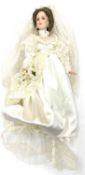 A porcelain doll formed as a bride, in white gown with lace veil and floral bouquet. height