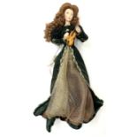 A Franklin Heirloom porcelain doll on stand, formed as a continental lady in green and gold velvet