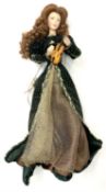 A Franklin Heirloom porcelain doll on stand, formed as a continental lady in green and gold velvet