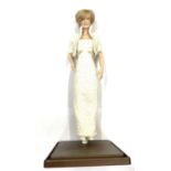 A porcelain doll on stand, modelled as the late Diana, Princess of Wales.Height approximately 44cm
