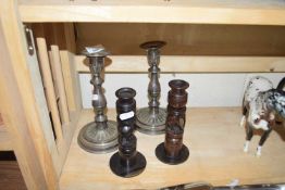 Pair of silver plated candlesticks together with a pair of African hardwood candlesticks