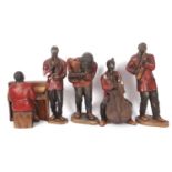 A quintet of 1920s porcelain music shop advertising statuettes, formed as an African-American jazz
